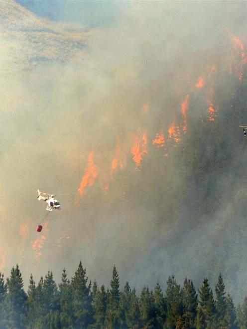 Helicopters battle the blaze on Thursday. Photo ODT files