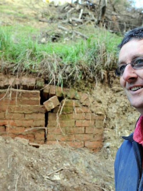 Henley farmer James Adam in front of the hidden stucture which was uncovered by a recent landslip...