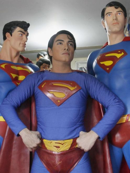 Herbert Chavez poses with his life-sized Superman statues inside his house in Calamba Laguna,...