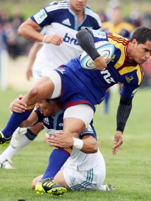 Highlander Aaron Smith in the tackle of Chris Smylie in the preseason Investec Super rugby match...