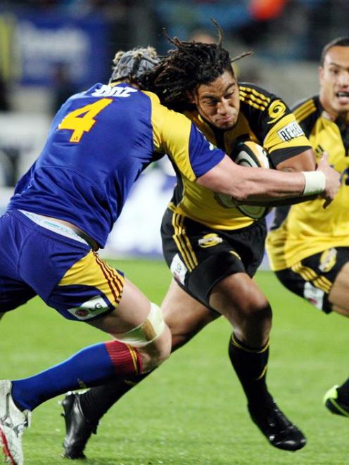 Highlander Josh Bekhuis, left, tackles Hurricanes back Ma'a Nonu in the Super 14 Rugby match at...