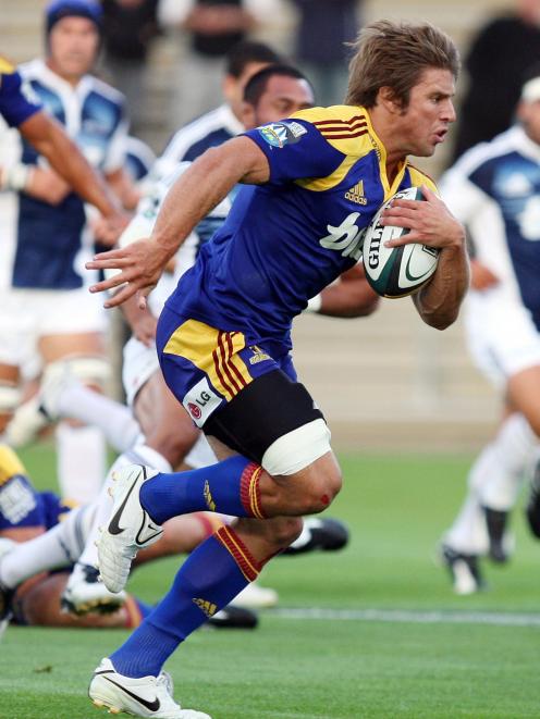 Highlander's James Paterson makes a break against the Blues in the Super 14 Rugby match at...