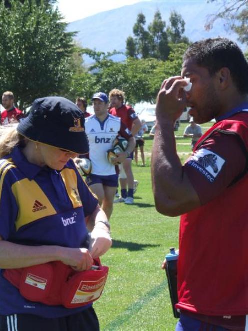 Highlanders doctor Sandy Webb treats a cut to loose forward Alando Soakai yesterday after a head...
