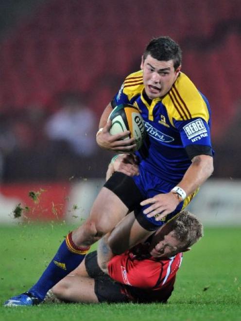 Highlanders first five-eighth Jayden Hayward is  tackled by Lions halfback Jano Vermaak during...