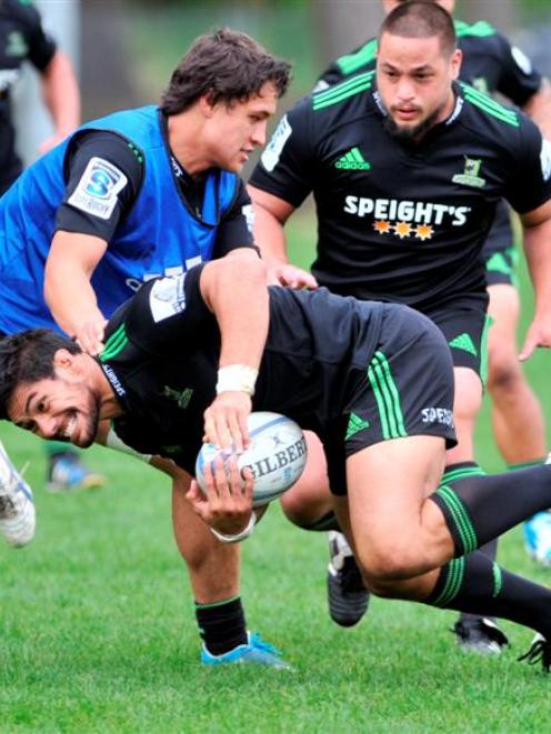 HIghlanders flanker Shane Christie is lowered by Lee Allan at training at Logan Park yesterday...