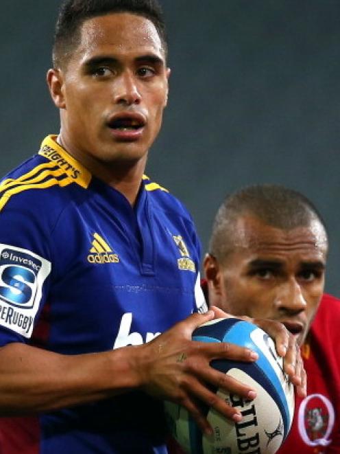 Highlanders halfback Aaron Smith is watched by Reds counterpart Will Genia during their Super 15...