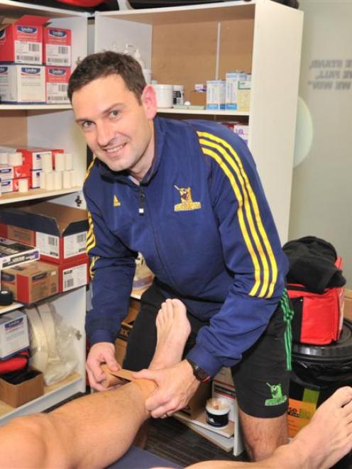 Highlanders physiotherapist Adam Letts straps a player's ankle at the Highlanders' headquarters...