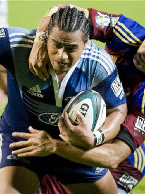 Highlanders second five-eighth Daniel Bowden attempts unsuccessfully to stop Blues halfback...