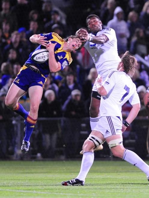 Highlanders wing Ben Smith grabs at a high ball ahead of Stormers counterpart Gcobani Bobo in...