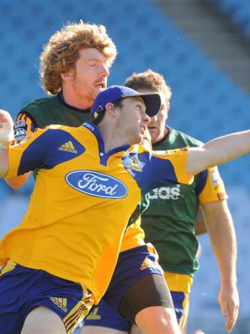 Highlanders winger Ben Smith tries to control the ball under pressure from loose forward Adam...