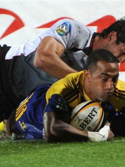 Highlanders winger Fetu'u Vainikolo is tackled by Sharks No 8 Ryan Kankowski as he attempts to...