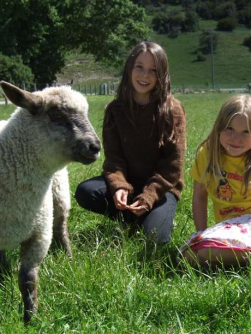 Hillary (11) and Fiona Hunt (6) with pet lamb Benny.