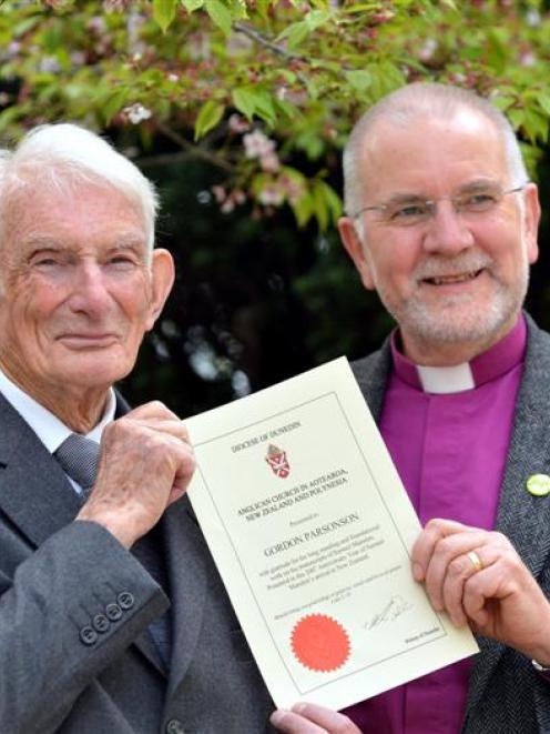 Historian Gordon Parsonson (left) holds a certificate, presented to him by the Anglican Bishop of...