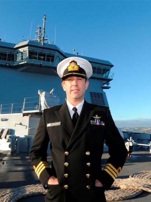 HMNZS Canterbury commanding officer Commander Sean Stewart surveys Dunedin from the ship's deck...