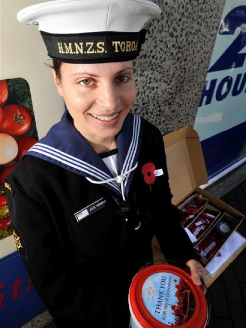 HMNZS Toroa leading hand Julie Harwood, of Dunedin, sells Anzac poppies on George St yesterday...