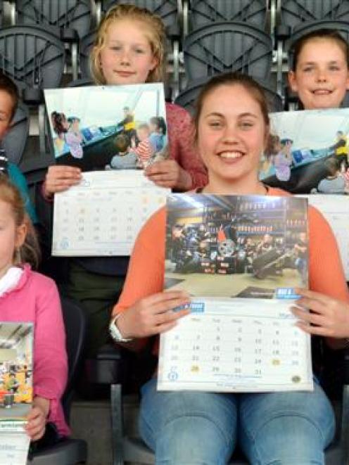 Holding fundraising calendars are some of the youngsters featuring in its photographs (front,...