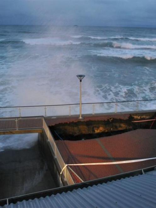 Holes in the St Clair esplanadecontinue to grow on Monday evening. Photo by Craig Baxter.