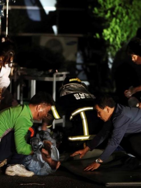 Hospital officials attend to a patient rescued from the fire. REUTERS/Hyung Min-woo/Yonhap