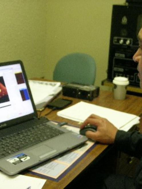 Hydrographic survey technician Warrant Officer Bernie Reihana looks at an item of interest in a...