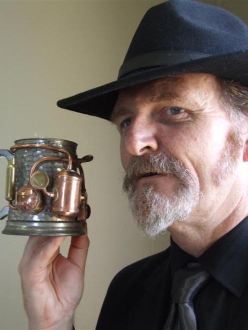 Iain Clark holds a steam-powered beer tankard on display in a steampunk exhibition at the...