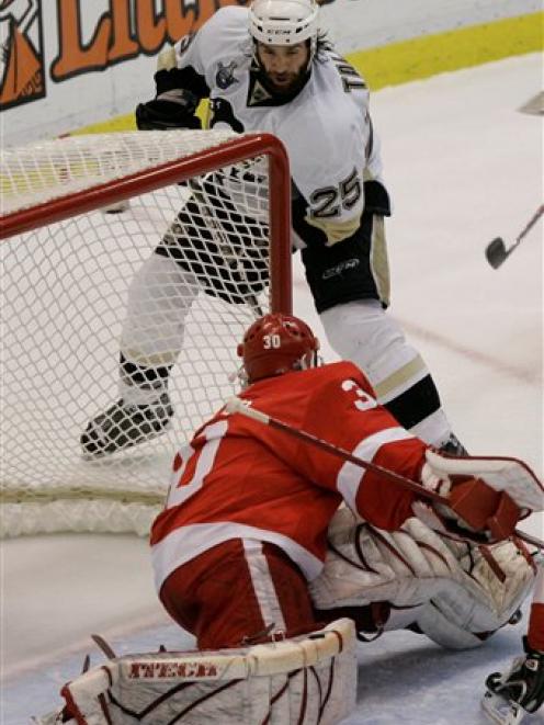 Pittsburgh Penguins forward Maxime Talbot scores on Detroit Red Wings goalie Chris Osgood during...