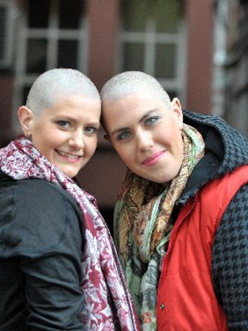 Caitlin Dunstan-Harrison (left) and Hannah Langford-Berman, with their freshly-shaved heads, pose...