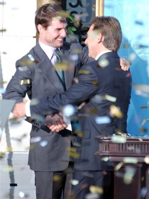 In this 2004 AP file photo, confetti rains down as U.S. actor Tom Cruise, left, embraces leader...