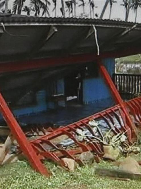In this image taken from video, a man stands next to a destroyed houses in Suva, Fiji, after...