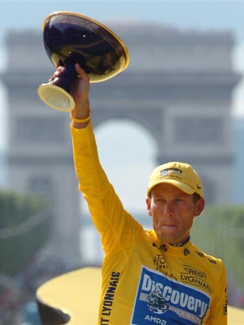 In this July 24, 2005 file photo, Lance Armstrong, of Austin, Texas, holds the winner's trophy...