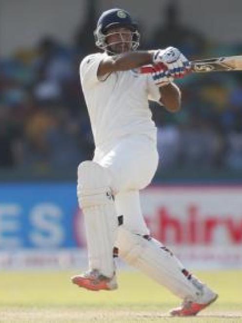 India's Cheteshwar Pujara plays a pull shot to the boundary during his century on day two of the...