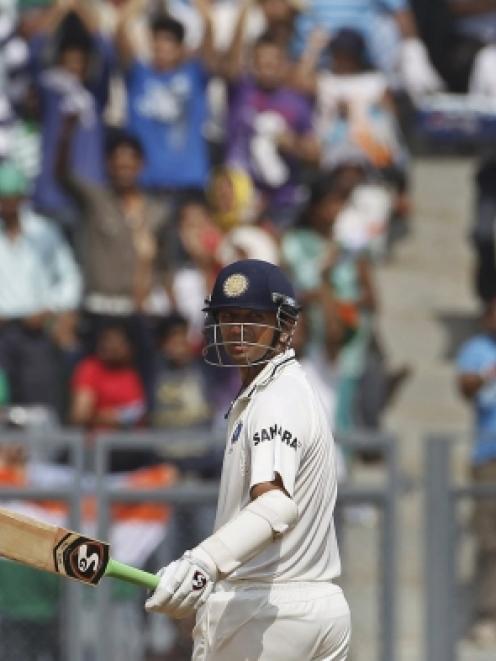 India's Rahul Dravid celebrates after completing 13,000 test runs while playing against West...