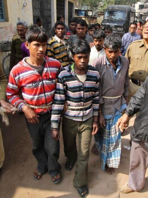 Indian police personnel escort men (tied with rope) accused of the gang-rape to a court at...