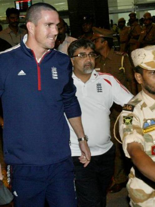 Indian security personnel escort England cricket captain Kevin Petersen as he arrives at the...
