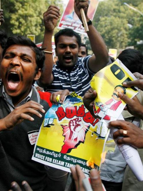 Indian Tamils tear and burn a poster of Sri Lankan President Mahinda Rajapaksa and Indian Prime...