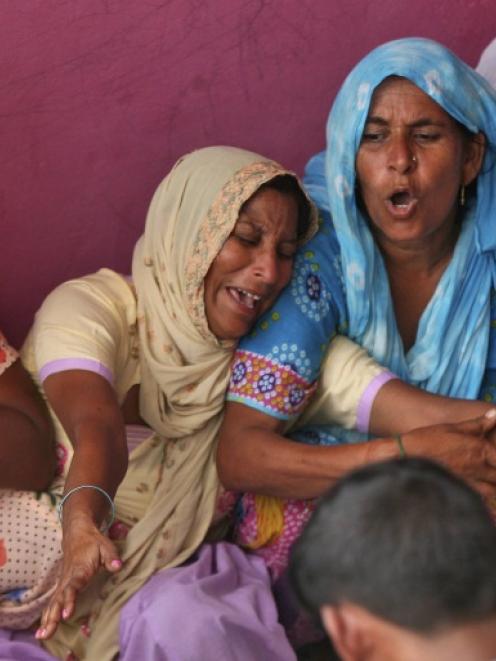 Indian villagers mourn the death of their relative whom locals say was killed by firing from the...