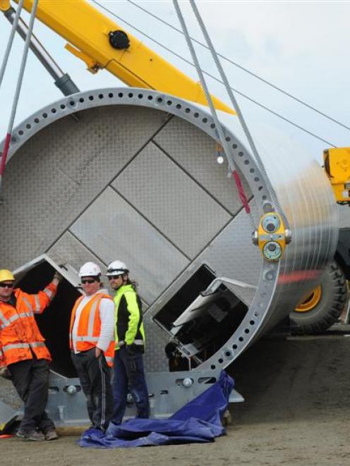 Installation crew wait out the wind beside the base section of the first wind turbine column due...