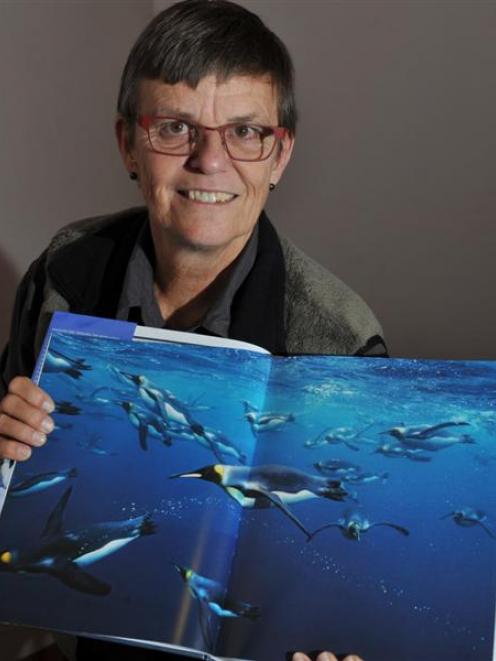 Internationally renowned New Zealand wildlife photographer Tui De Roy with the book on penguins...