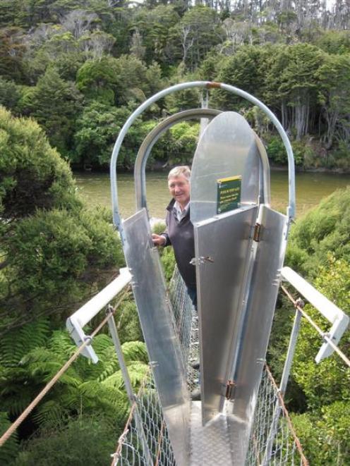 Invercargill MP Eric Roy inspects a possum-proof gate fitted to a bridge over the Waitutu River....