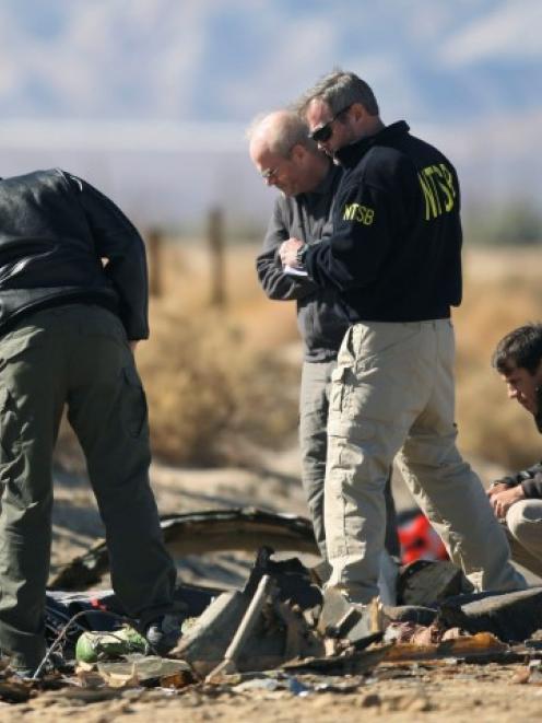 Investigators from the National Transportation Safety Board look at wreckage from the crash of...