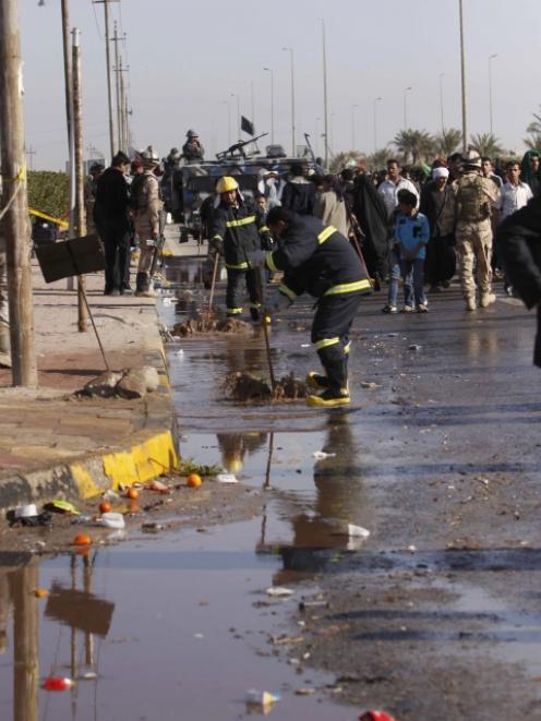 Iraqi security forces clean the scene of a bomb attack which killed at least 53 people and...