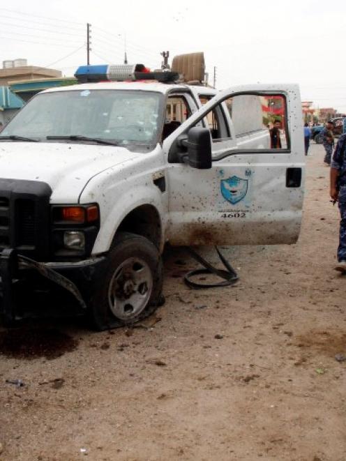 Iraqi security forces inspect the site of a suicide bombing outside a polling station in Kirkuk....