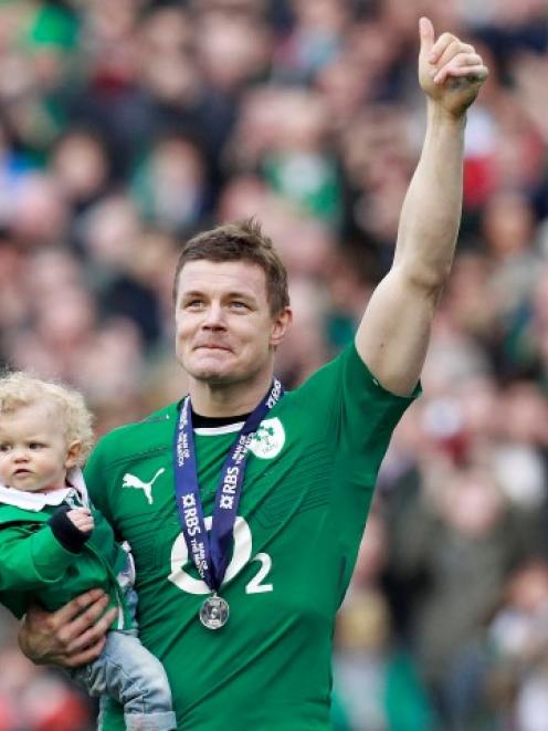 Ireland's Brian O'Driscoll carries his daughter Sadie at the end of their Six Nations match...