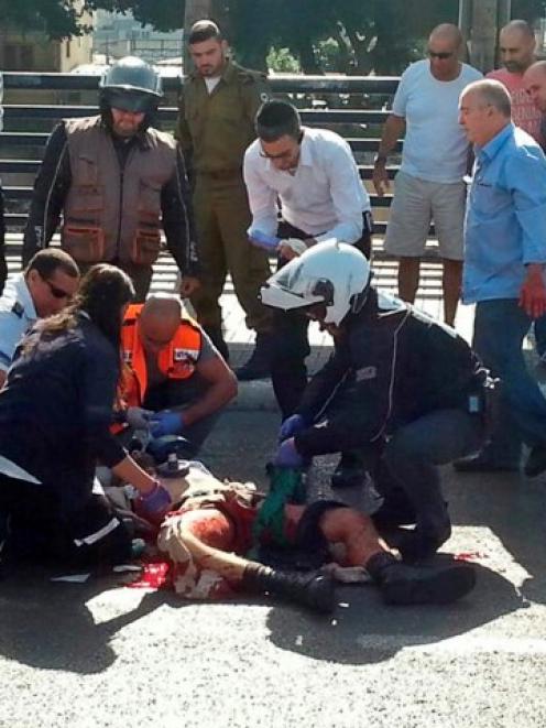 Israeli medics treat a wounded soldier at the scene of a stabbing attack in Tel Aviv. REUTERS...