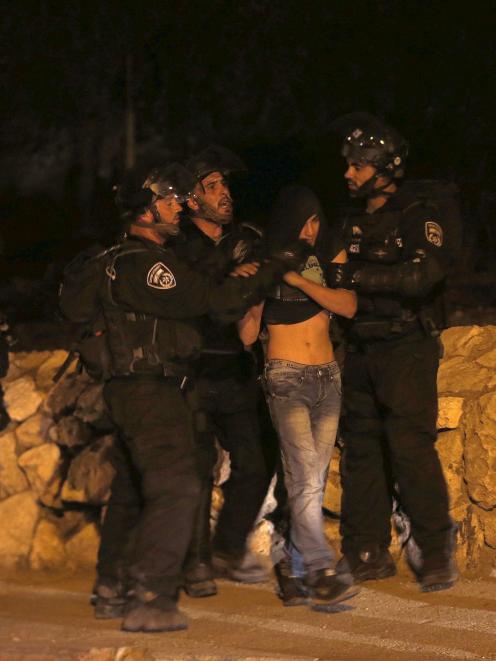 Israeli police officers detain a Palestinian youth during clashes in the east Jerusalem...