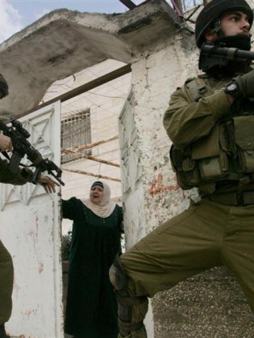 Israeli soldiers move into position during clashes with Palestinian protesters near Qalandiya...