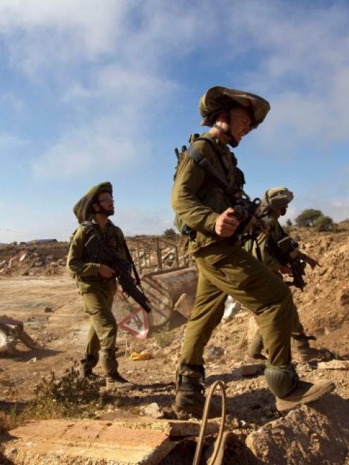 Israeli soldiers walk during training close to the ceasefire line between Israel and Syria on the...