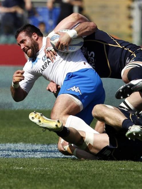 Italy's Robert Barbieri, left, is tackled by Scotland' s Ross Rennie and David Tenton (top)...