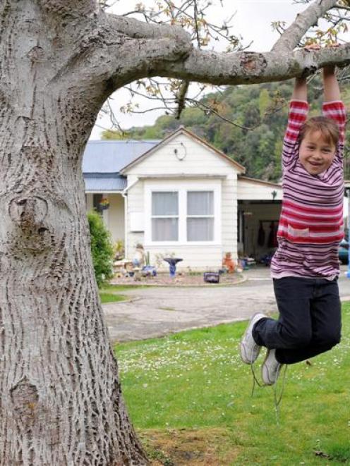 Jaedah Cook (7) swings from a tree on her family's contaminated Otago Regional Council rental...