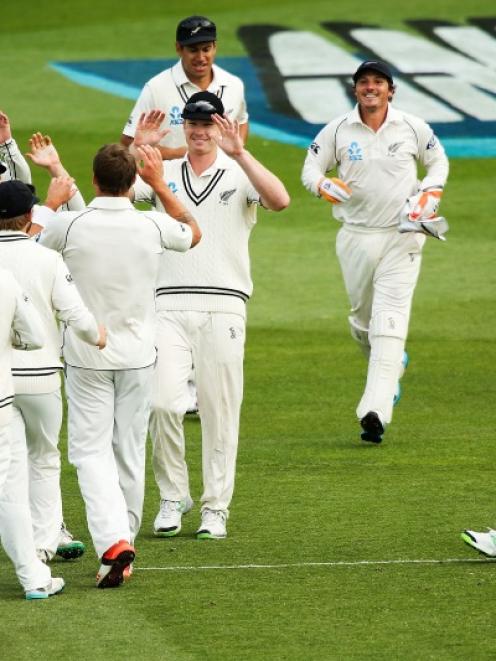 James Neesham of New Zealand (centre) celebrates with teammates after taking a catch to dismiss...