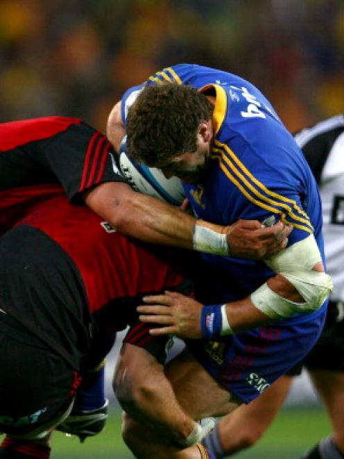 Jamie MackIntosh of the Highlanders comes off second best against the Crusaders defence in their...